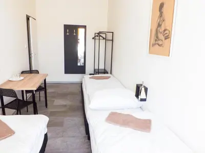 a room with three beds and a table and a table at Two-room apartment near the center F2 in Prague