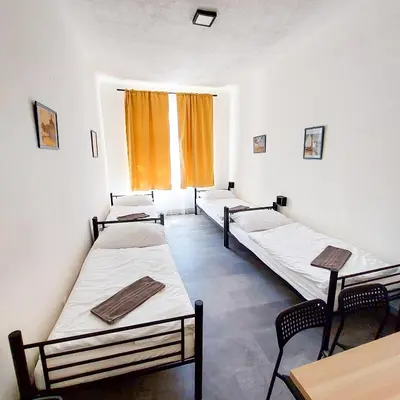 a room with three beds and a window at Traveller's room F1 u výstaviště in Prague