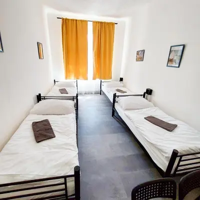 three beds in a room with a window at Traveller's room F1 u výstaviště in Prague