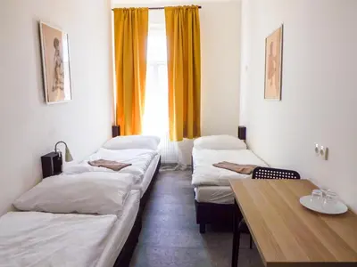 a room with three beds and a table and a window at Sunny room in centre of Prague H1 in Prague
