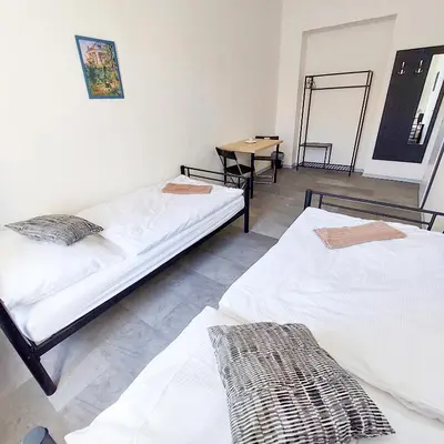 two beds sitting in a room with a table at Prague room Letná H2 in Prague