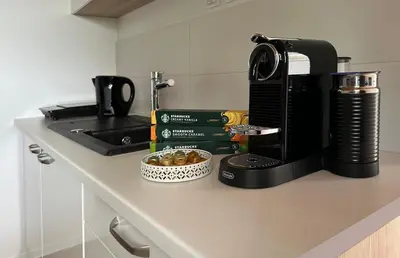 a kitchen counter with a coffee maker and books on it at Glamping Prokop in Prague