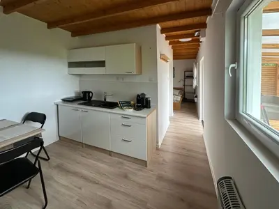 a kitchen with white cabinets and a table and a window at Glamping Prokop in Prague