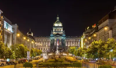 a large building with a clock tower at night at Practical room near the main station H3 in Prague