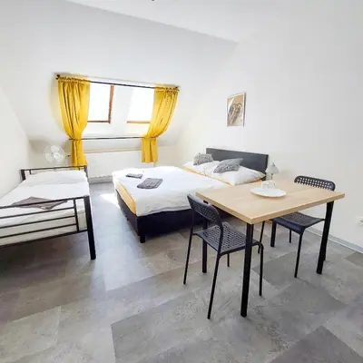 a bedroom with a bed and a table and chairs at Beautiful attic room R3 in Prague