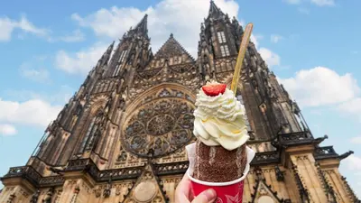 a person holding a ice cream cone in front of a building at Beautiful attic room R3 in Prague