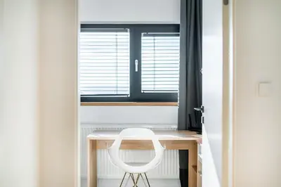 a white chair sitting at a desk in front of a window at Dvouložnicový mezonetový apartmán se dvěma koupelnami v rodinné vile in Prague