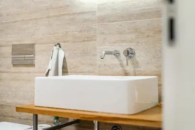 a white sink in a bathroom with tiles at Dvouložnicový mezonetový apartmán se dvěma koupelnami v rodinné vile in Prague