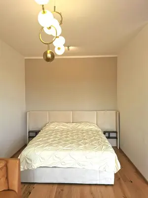 a bedroom with a white bed and a chandelier at free private Parking, central location, Nuslesky Pivovar sunset balcony home, in Prague