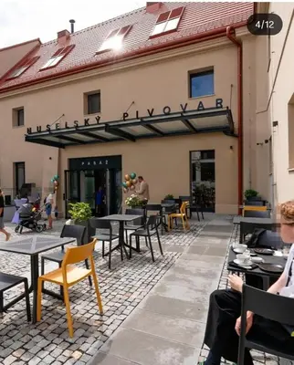 a patio with tables and chairs in front of a building at free private Parking, central location, Nuslesky Pivovar sunset balcony home, in Prague