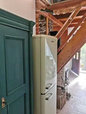 a refrigerator in a kitchen with a green door at fairy tale cottage on water stream, 30 minutes from South Prague in Davle