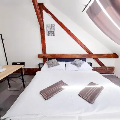 a bedroom with two white beds and a table at Útulný podkrovní pokoj R4 v Praze in Prague
