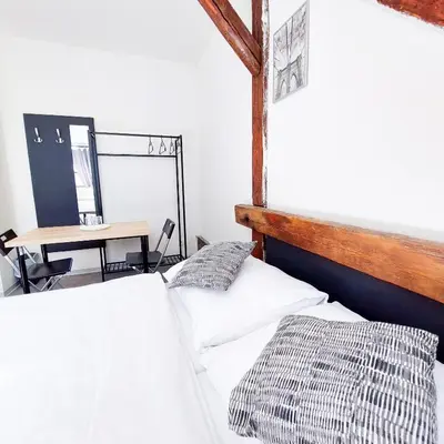 a bedroom with a bed and a table with a desk at Útulný podkrovní pokoj R4 v Praze in Prague