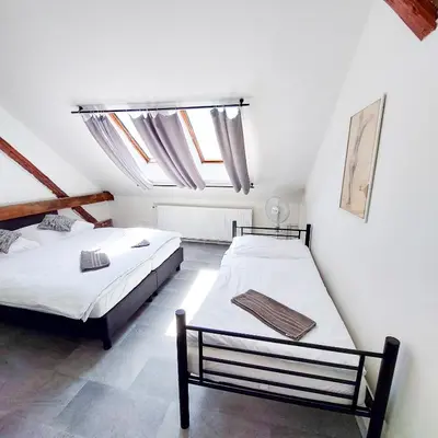 a bedroom with two beds and a window at Útulný podkrovní pokoj R4 v Praze in Prague