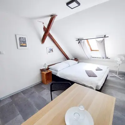 a room with two beds and a table at Romantický pokojíček v podkroví R5 in Prague