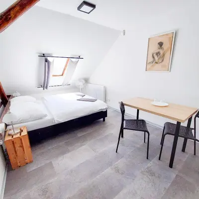 a bedroom with a bed and a desk and a table at Romantický pokojíček v podkroví R5 in Prague