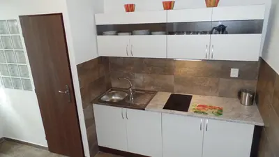 a kitchen with white cabinets and a sink at Apartments Rokytka - Praha in Prague