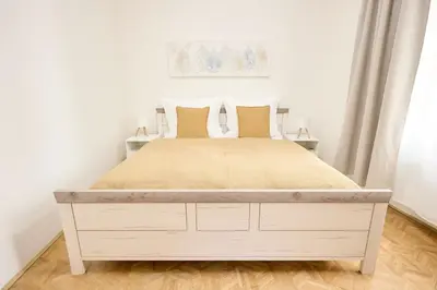 a bedroom with a large bed with yellow pillows at Alma Apartments in Prague