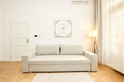 a white living room with a couch and a door at Alma Apartments in Prague