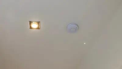 a light in a bathroom with a white wall at Garden house on the Vltava riverbank 15 min to Prague in Kralupy nad Vltavou