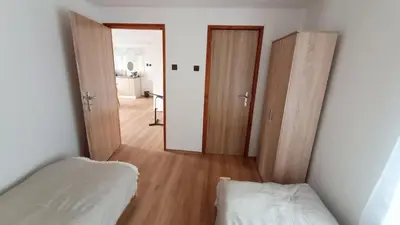 a room with two beds and a hallway with two doors at Apartmán Mělník 330 in Mělník