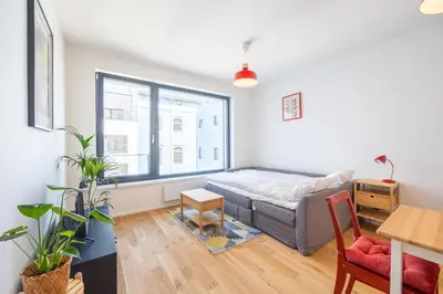 a living room with a bed and a table at Peaceful and cosy newly built studio with parking in Prague