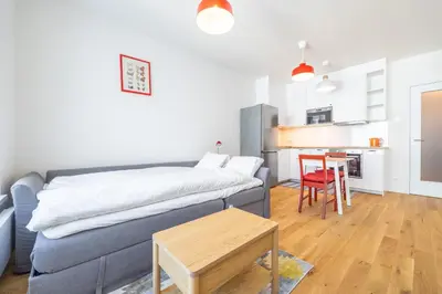 a living room with a couch and a table at Peaceful and cosy newly built studio with parking in Prague