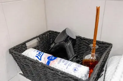 a basket with a bottle of alcohol and a microphone at Peaceful and cosy newly built studio with parking in Prague