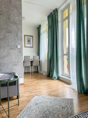 a living room with a table and a window at Sunny Flat with Terrace & Park View Near City Centre in Prague