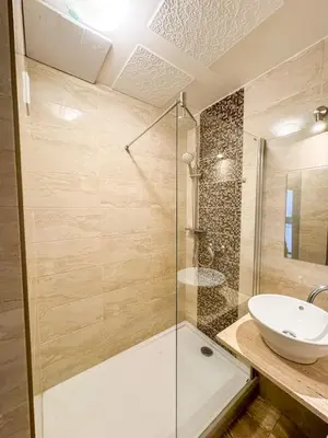 a bathroom with a glass shower and a sink at Sunny Flat with Terrace & Park View Near City Centre in Prague