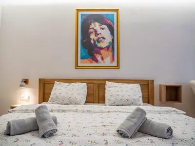 two beds in a bedroom with a painting on the wall at Apartmán Mick Jagger in Nymburk