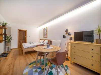a room with a bed and a table and a tv at Apartmán Mick Jagger in Nymburk