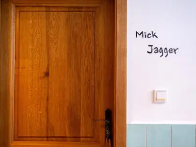 a wooden door with a sign on the side of a building at Apartmán Mick Jagger in Nymburk