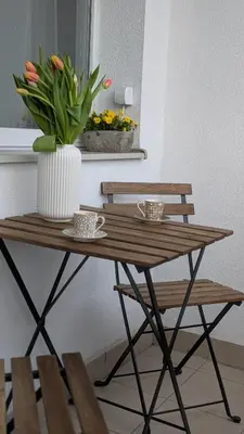 a wooden table with a vase of flowers on it at Stylish Prague 6 Apartment with balcony in Prague