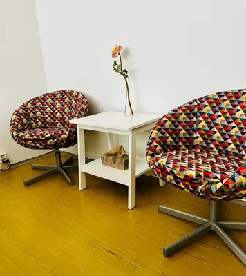two chairs and a white table with a vase on it at Stylish Prague 6 Apartment with balcony in Prague