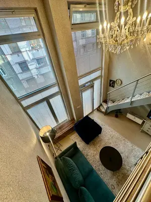 a living room with a green couch and a chandelier at Loft Ballerina in Prague