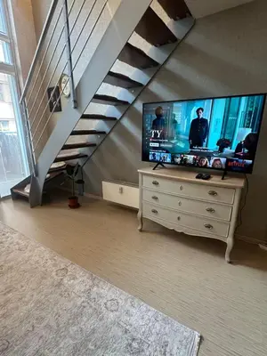 a living room with a tv and a staircase at Loft Ballerina in Prague