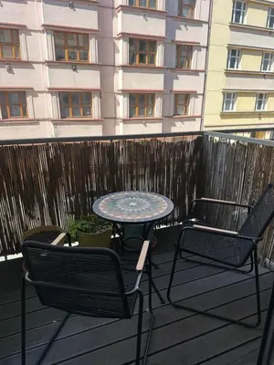 a table and chairs on a balcony with a building at Loft Ballerina in Prague