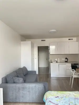 a living room with a couch and a kitchen at Harmony106 in Prague