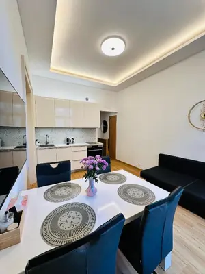 a living room with a table and chairs and a kitchen at Old Town Prague Apartment in Prague