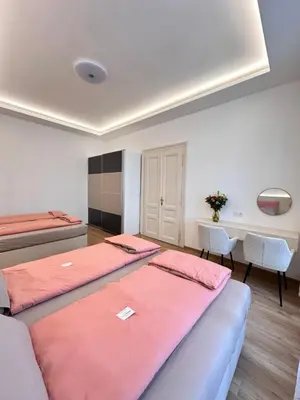 a room with three beds and a desk and a table at Old Town Prague Apartment in Prague