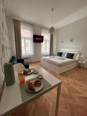 a room with a bed and a table with food on it at Studio Oliver in Prague