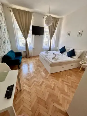 a bedroom with a white bed and a wooden floor at Studio Oliver in Prague
