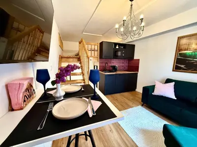 a living room with a table and a couch at Apartment Divadelni - Historic Center & steps from Charles Bridge in Prague
