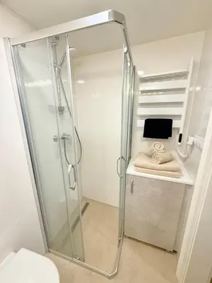 a shower with a glass door in a bathroom at Apartment Divadelni - Historic Center & steps from Charles Bridge in Prague