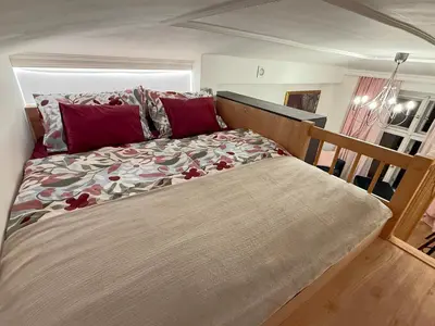 a large bed in a bedroom with red pillows at Apartment Divadelni - Historic Center & steps from Charles Bridge in Prague