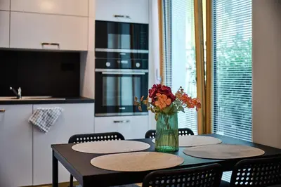 a table with two chairs and a vase of flowers on it at Residence Kobrova with free parking in Prague