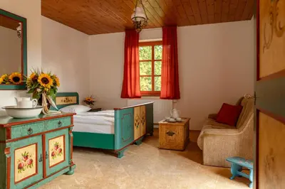 a bedroom with a bed and a chair and a window at Penzion Ztracený mlýn in Slapy