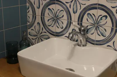 a white sink in a bathroom with a tile wall at Penzion Ztracený mlýn in Slapy