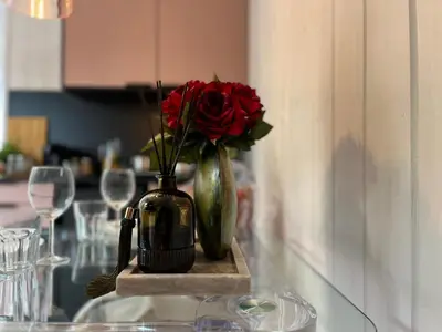 a vase with a red rose in it on a table at Garden Residence - The Lotus in Drahobudice